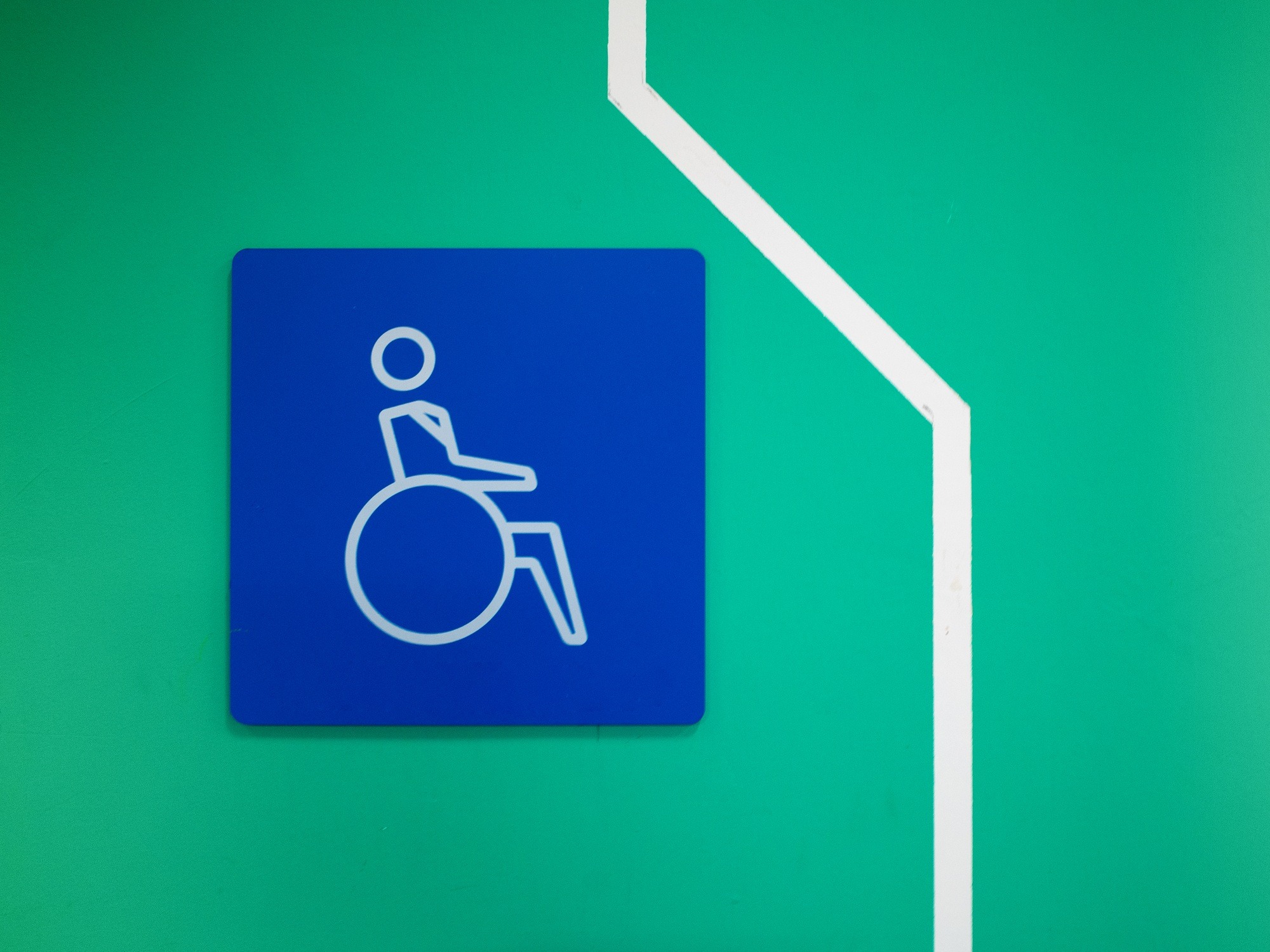 Disabled Parking, Disability symbol paint on green wall